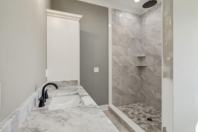 full bath with a tile shower and vanity