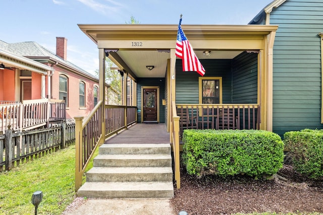 property entrance with fence and a porch