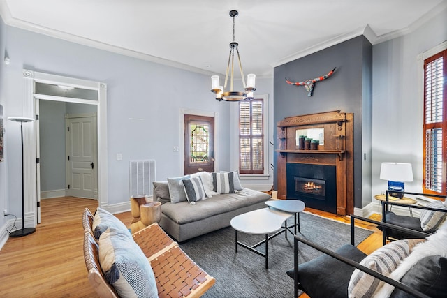 living area featuring light wood-style floors, a glass covered fireplace, a healthy amount of sunlight, and visible vents