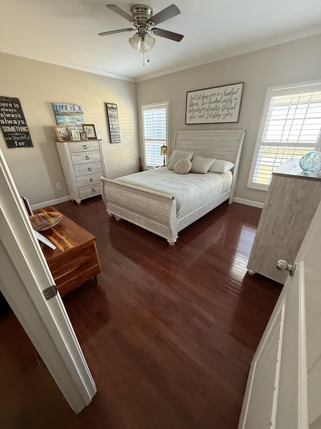 bedroom with baseboards, multiple windows, wood finished floors, and crown molding