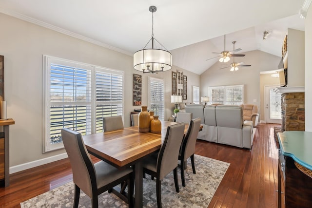 dining space with dark wood-style floors, a healthy amount of sunlight, baseboards, and vaulted ceiling