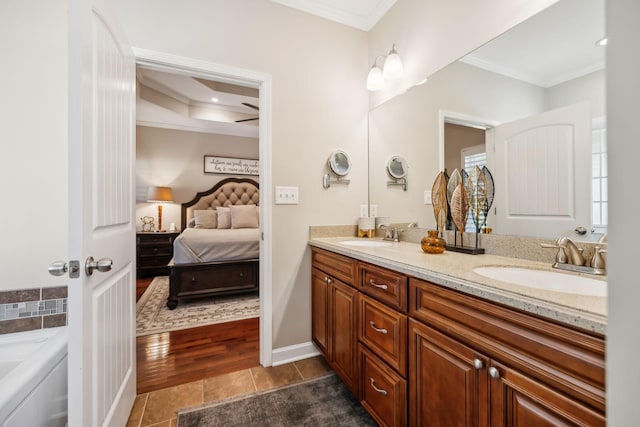 full bath with a sink, ensuite bath, tile patterned floors, and ornamental molding