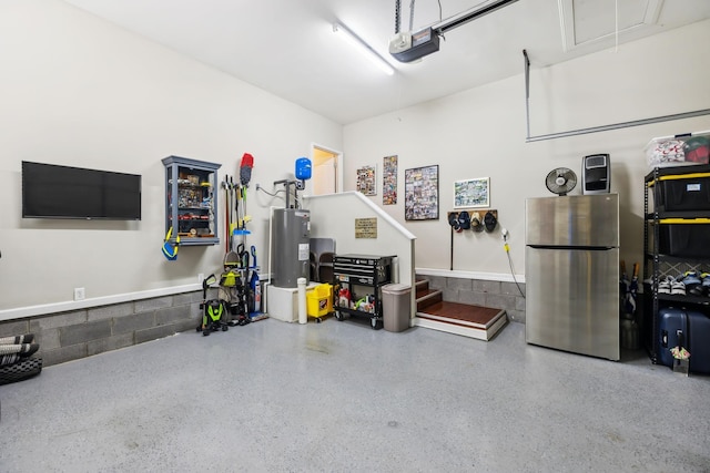 garage featuring a garage door opener, water heater, and freestanding refrigerator