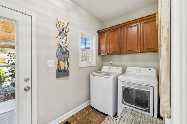 laundry room featuring baseboards, cabinet space, separate washer and dryer, and dark tile patterned floors