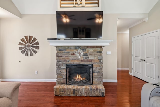 living room featuring baseboards, wood finished floors, a fireplace, and ornamental molding