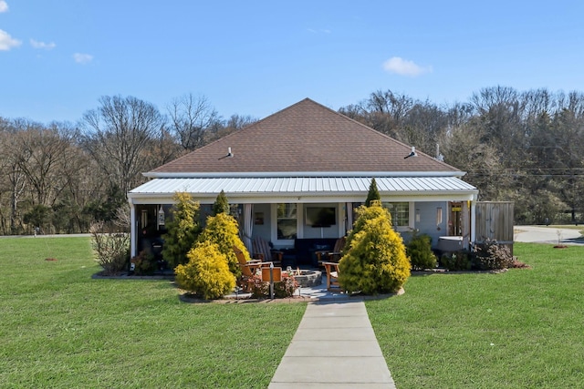 view of front of property with covered porch, metal roof, and a front lawn