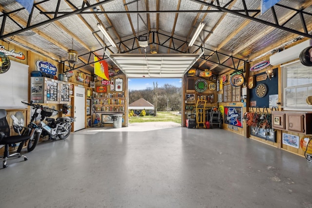 garage featuring a workshop area, metal wall, and a garage door opener