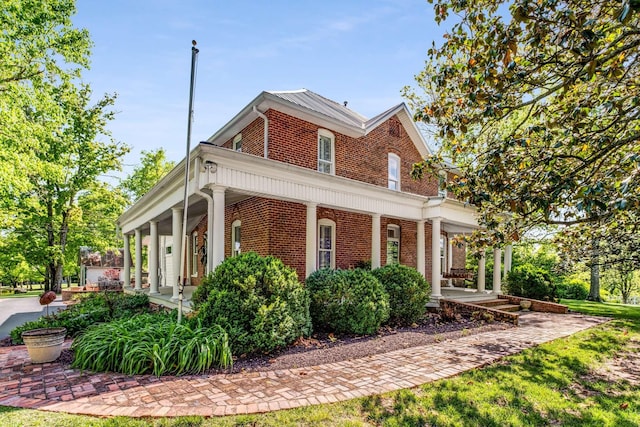 view of property exterior featuring a porch and brick siding