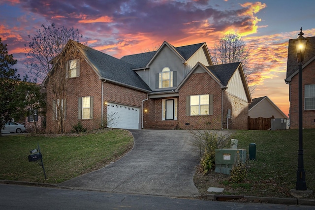 traditional-style home with driveway, a garage, a lawn, and brick siding