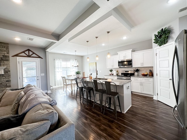 kitchen featuring appliances with stainless steel finishes, open floor plan, visible vents, and dark wood finished floors