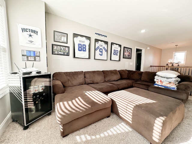 carpeted living area featuring an inviting chandelier