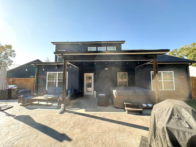 back of house featuring a patio, fence, and a hot tub