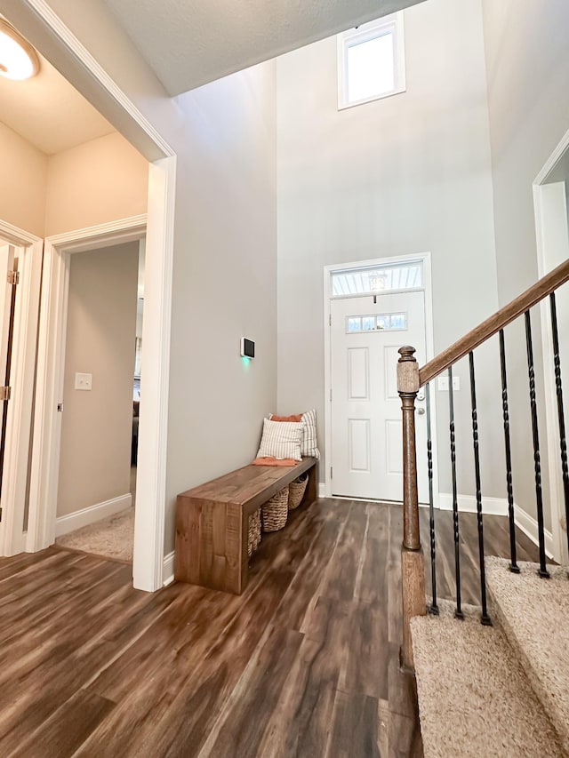 entryway featuring stairway, wood finished floors, and baseboards