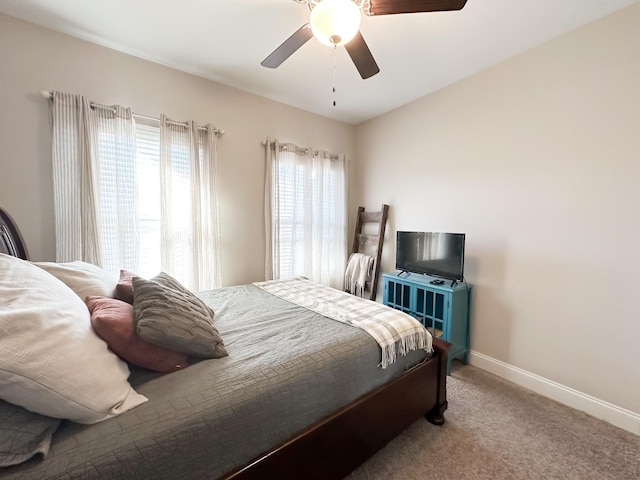 carpeted bedroom with ceiling fan and baseboards