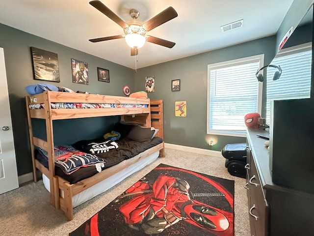 carpeted bedroom with a ceiling fan, visible vents, and baseboards