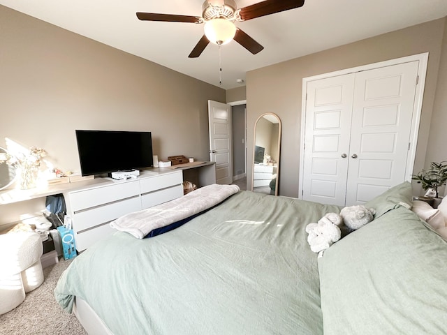 carpeted bedroom with ceiling fan and a closet