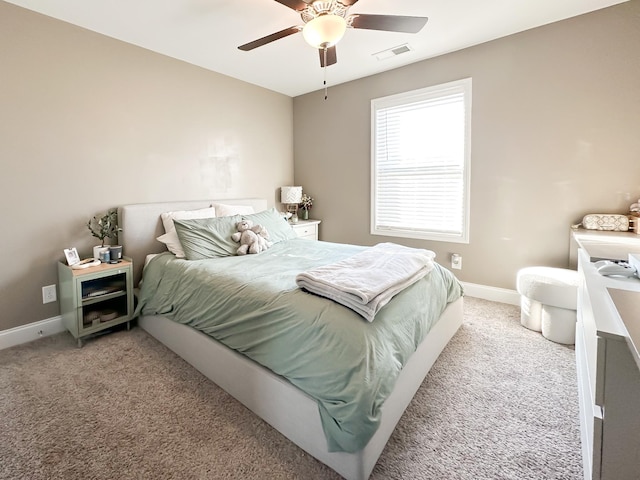 bedroom with light carpet, a ceiling fan, visible vents, and baseboards