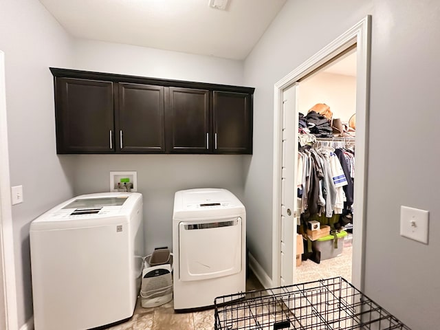 washroom with cabinet space and washer and dryer