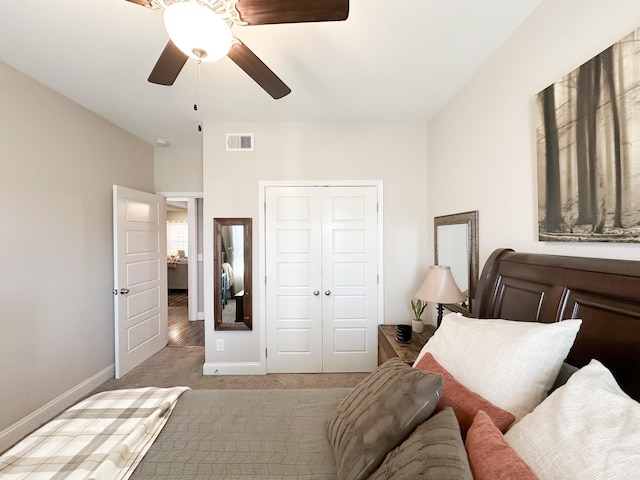 bedroom with baseboards, visible vents, ceiling fan, carpet, and a closet