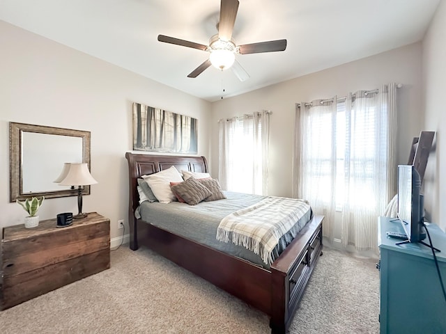 bedroom featuring light carpet, baseboards, and a ceiling fan