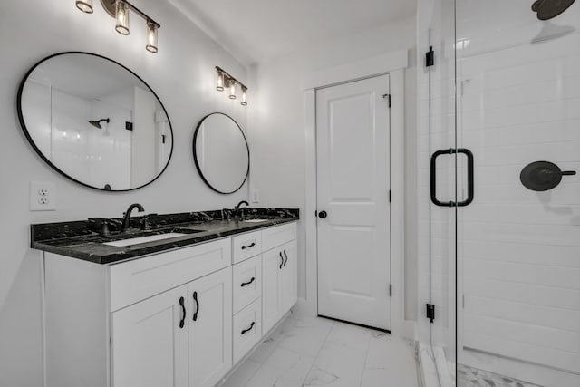 bathroom featuring double vanity, marble finish floor, a sink, and a stall shower