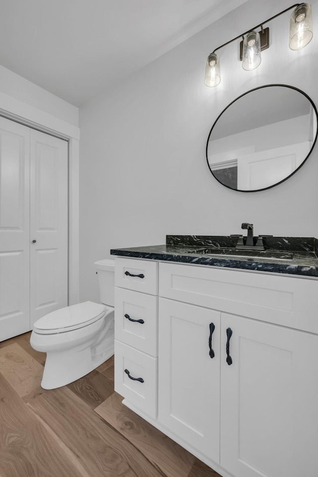 bathroom featuring vanity, toilet, and wood finished floors