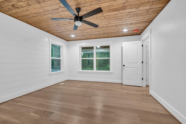 unfurnished room featuring light wood finished floors, wood ceiling, baseboards, and a ceiling fan