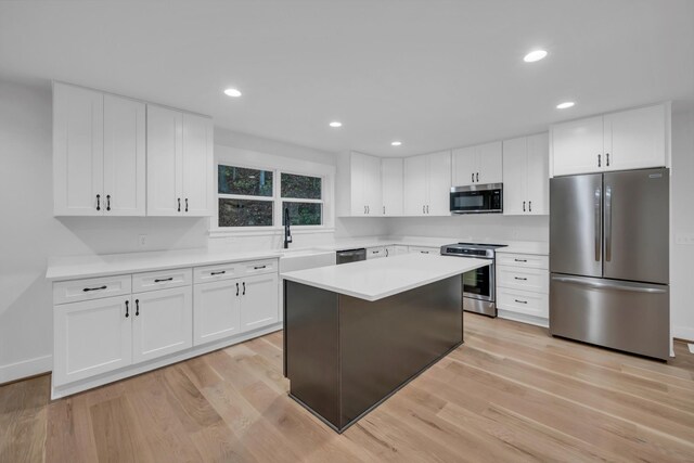 kitchen featuring light wood-style floors, stainless steel appliances, a sink, and light countertops