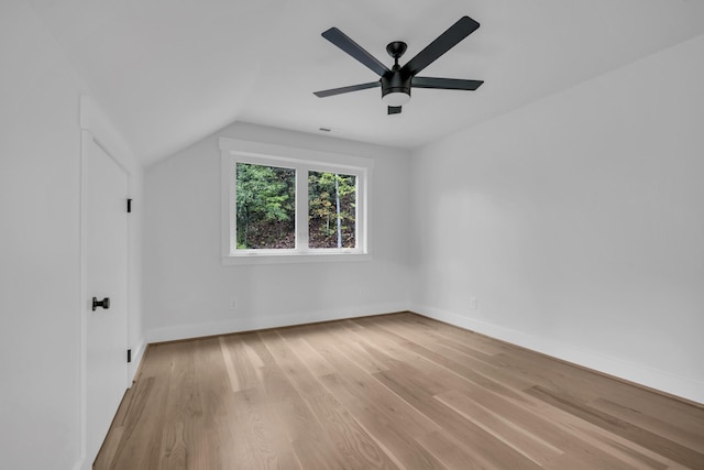 additional living space with vaulted ceiling, wood finished floors, a ceiling fan, and baseboards