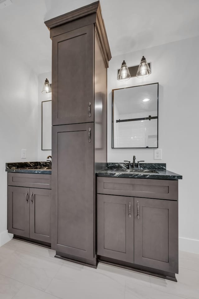 bathroom with two vanities, a sink, and baseboards