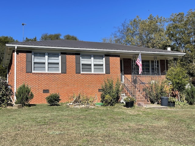 bungalow-style house featuring metal roof, brick siding, crawl space, and a front lawn