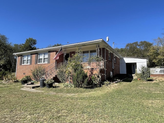 view of front of property featuring a front lawn, fence, and brick siding