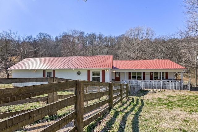 exterior space featuring metal roof and fence