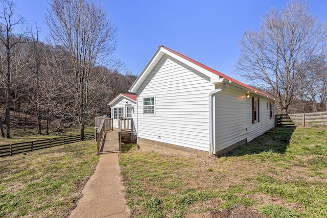 view of side of property featuring a yard and fence