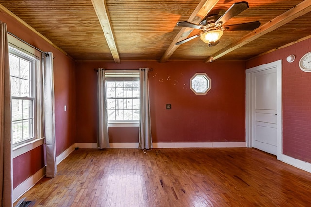 interior space with wood ceiling, a wealth of natural light, hardwood / wood-style flooring, and beam ceiling