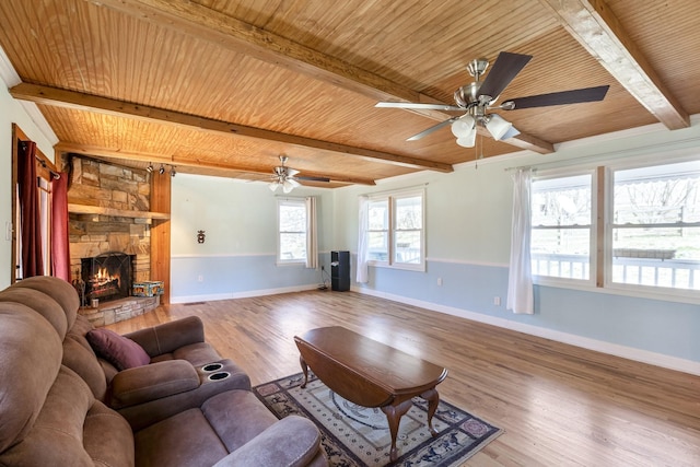 living area with a fireplace, wood finished floors, wood ceiling, baseboards, and beamed ceiling