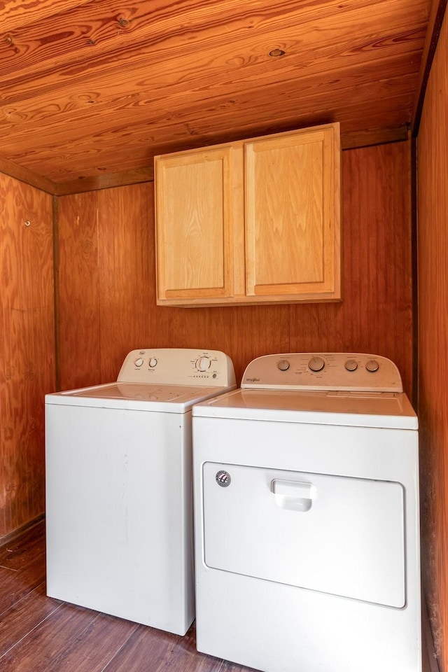 washroom with wooden ceiling, wooden walls, independent washer and dryer, cabinet space, and dark wood finished floors