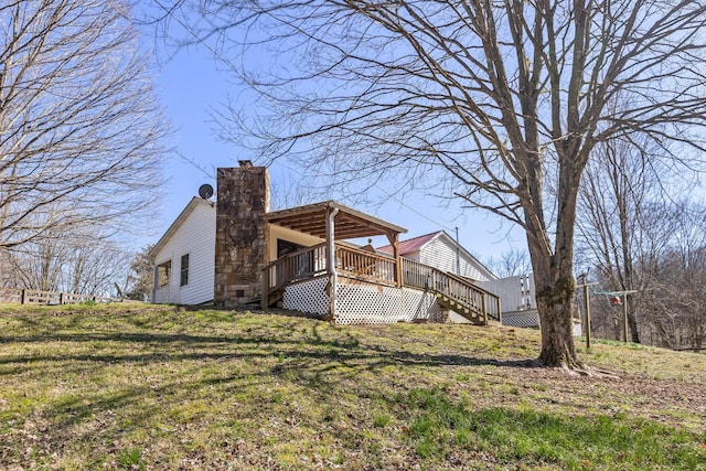 rear view of house with a yard, stairway, a chimney, and a wooden deck