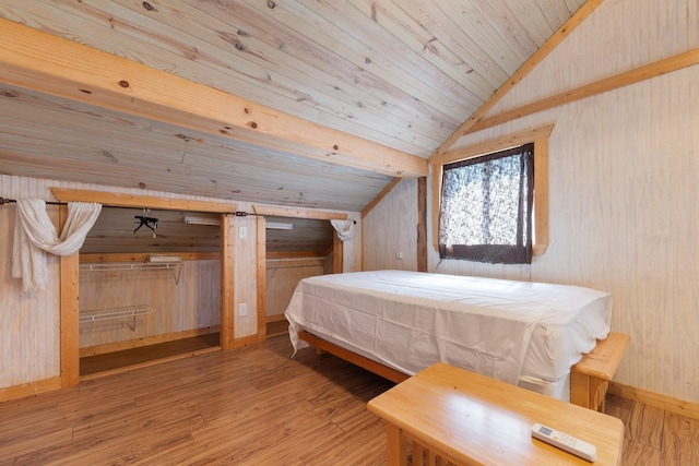 bedroom with lofted ceiling, wood ceiling, wooden walls, wood finished floors, and baseboards