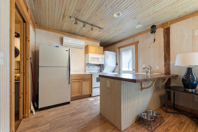 kitchen featuring white appliances, a breakfast bar area, a wall mounted air conditioner, light wood-style floors, and a sink