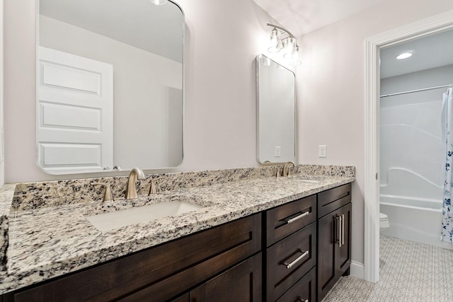 full bathroom with double vanity, toilet, shower / bath combo with shower curtain, and a sink