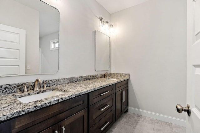 bathroom featuring double vanity, a sink, and baseboards