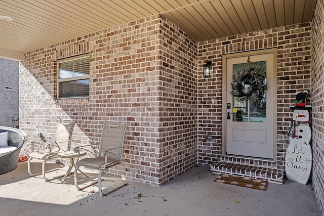 doorway to property with brick siding