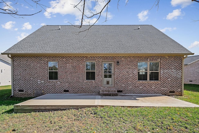 rear view of house with crawl space, a patio area, brick siding, and roof with shingles