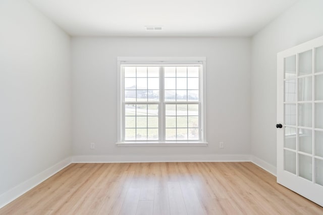 spare room featuring baseboards and wood finished floors