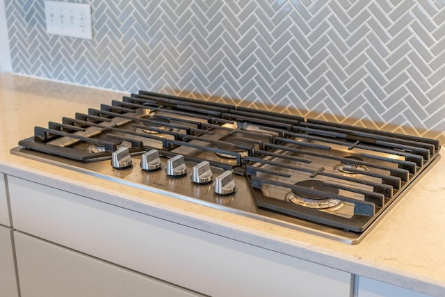 interior details with white cabinetry and stainless steel gas cooktop