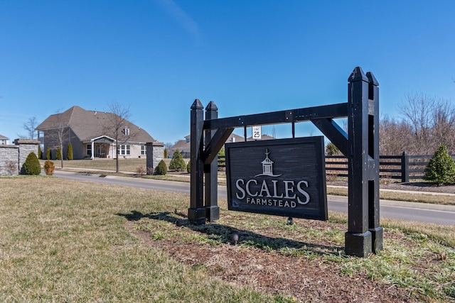 community sign with fence and a yard