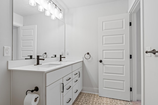 full bathroom with tile patterned floors, a sink, baseboards, and double vanity