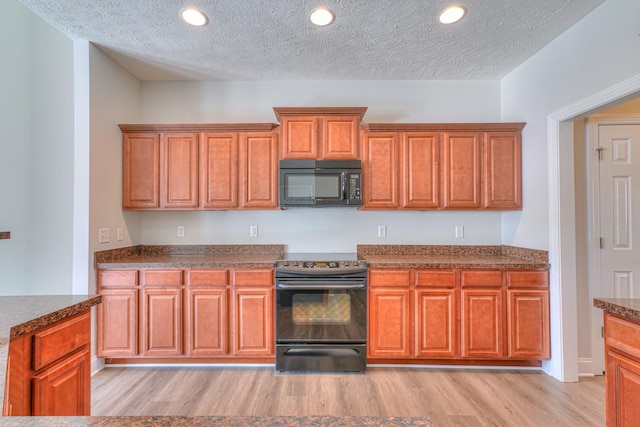 kitchen featuring light wood-type flooring, black appliances, brown cabinetry, and recessed lighting