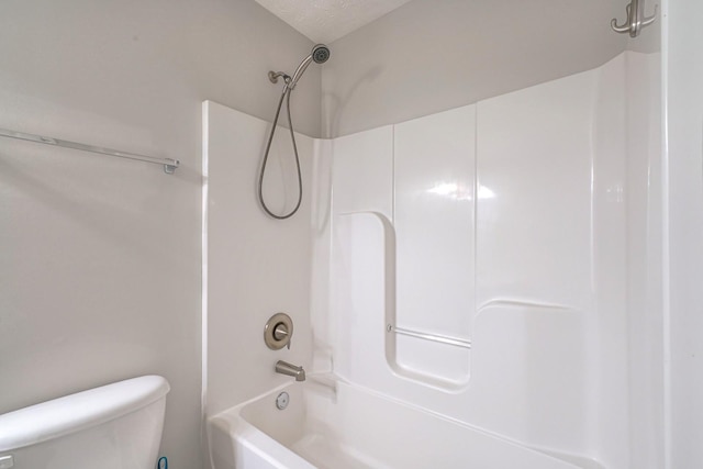 full bathroom with a textured ceiling, bathing tub / shower combination, and toilet